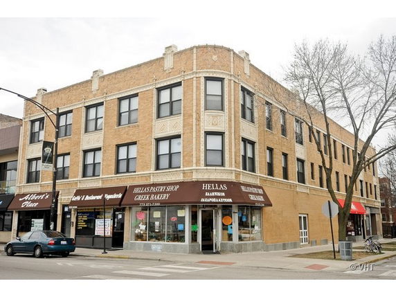 Front view of a three-story commercial building with retail shops on the ground floor.