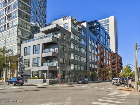 Front view of a multi-story residential building on a corner lot.