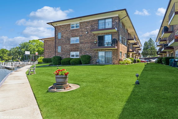 Front view of a multi-story brick apartment building with balconies.