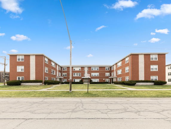 Front view of a three-story brick apartment building.