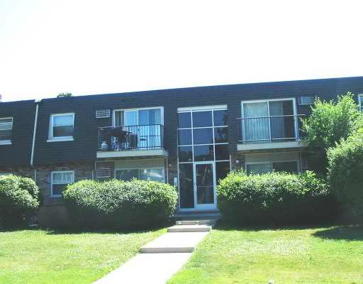Front view of a two-story residential building with a central entrance and balconies.
