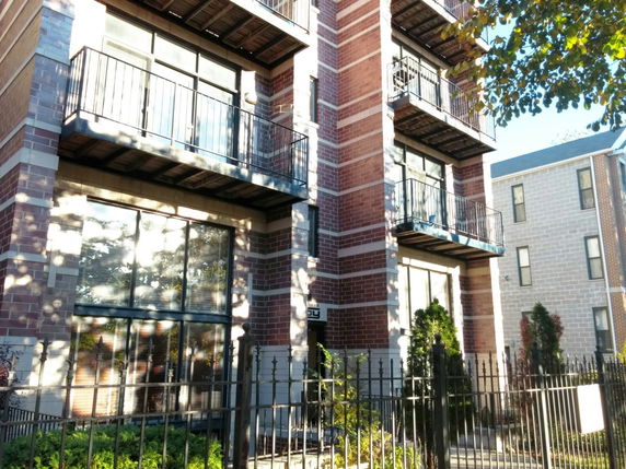 Front view of a multi-story brick building with balconies.