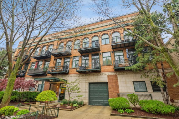 Front view of a multi-story building with brick facade and balconies.