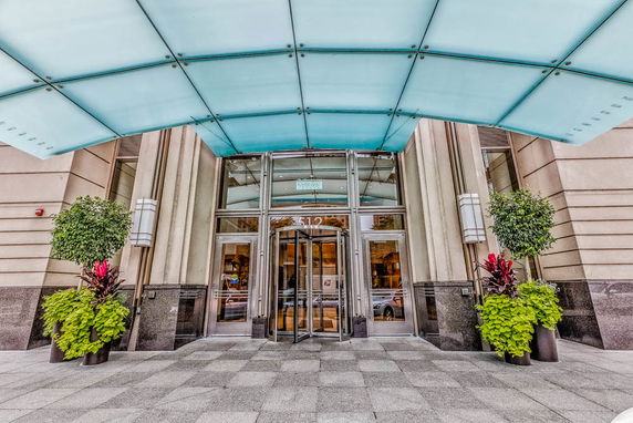 Front view of a building entrance with a revolving door and glass canopy.