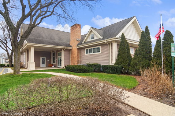 Front view of a house with a chimney and covered entrance.