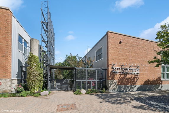 Front view of a brick building with metal accents and an entrance gate.