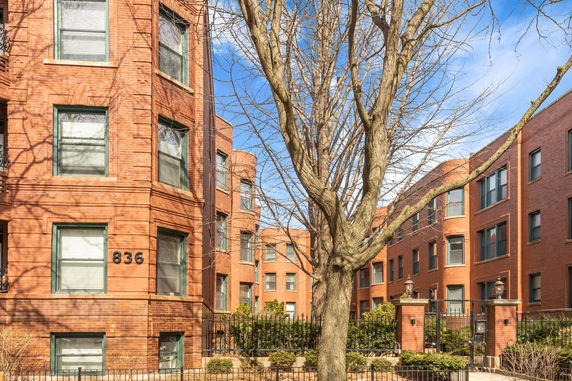 Front view of a red brick multi-story building with multiple windows.