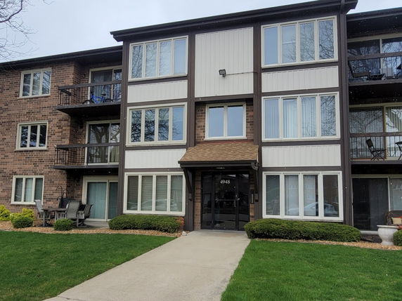 Front view of a three-story apartment building with balconies.