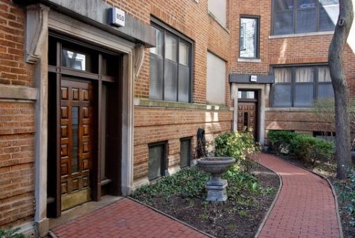 Front view of a brick building with two main entrances and a walking path.