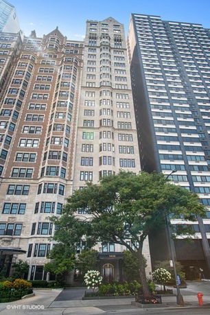Front view of a tall multi-story building with intricate architectural details.