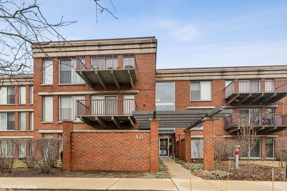 Front view of a multi-story brick residential building with balconies.