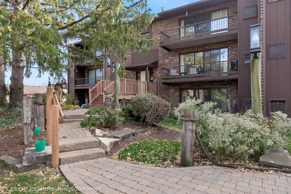 Front view of a multi-story residential building with brick facade and balconies.