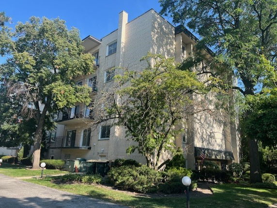 Front view of a multi-story apartment building with balconies on each floor.