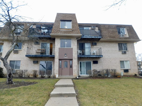 Front view of a multi-story apartment building with balconies.