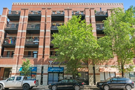 Front view of a multi-story brick building with balconies.