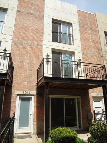 Front view of a multi-story townhouse with balconies.