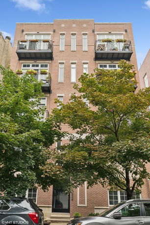 Front view of a multi-story brick building with balconies.