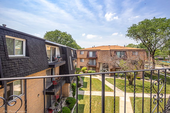 Panoramic view of apartment buildings with balconies and a communal courtyard.