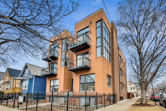 Front view of a modern multi-story brick building with balconies.