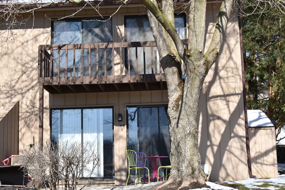Front view of a two-story house with a wooden balcony.