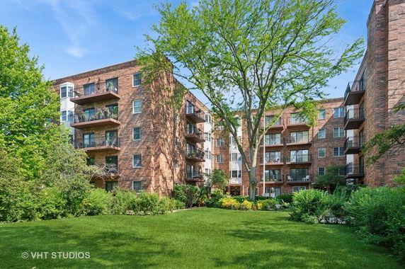 Front view of a multi-story brick apartment building with balconies.