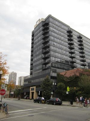 Front view of a multi-story building with balconies and glass windows.