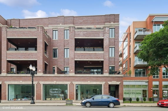 Front view of a multi-story commercial building with balconies and storefronts.