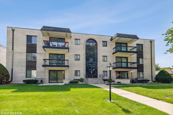 Front view of a multi-story apartment building with balconies.
