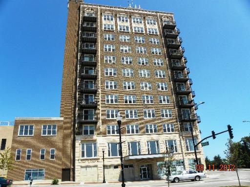 Front view of a tall brick building with multiple windows and balconies.