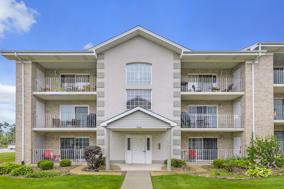 Front view of a three-story apartment building with balconies.