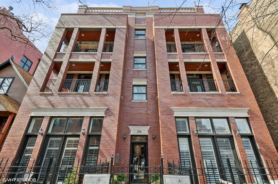 Front view of a multi-story brick building with balconies.