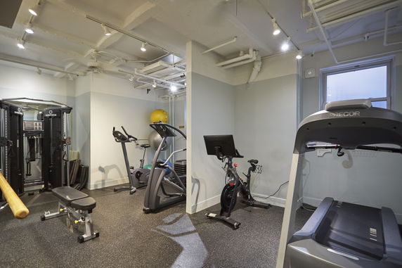 Indoor gym area with exercise equipment including a treadmill and stationary bikes.