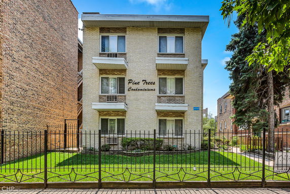 Front view of a three-story condominium building with balconies.