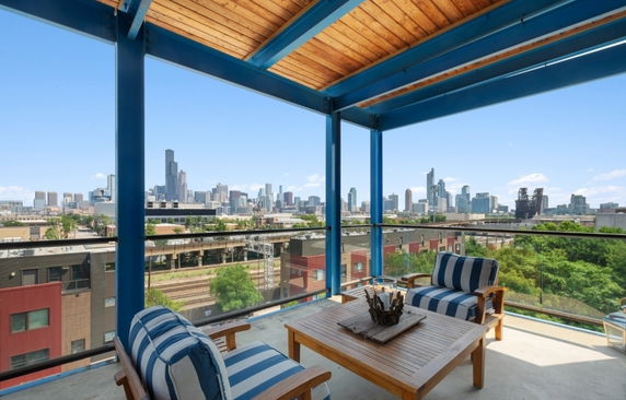 Outdoor seating area with a panoramic view of a city's skyline.