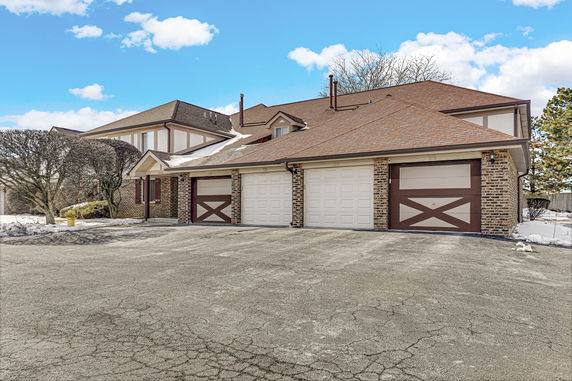 Front view of a house with a three-car garage and a sloped roof.