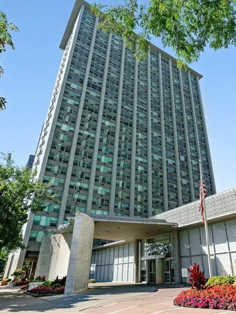 Front view of a tall multi-story building with numerous windows.