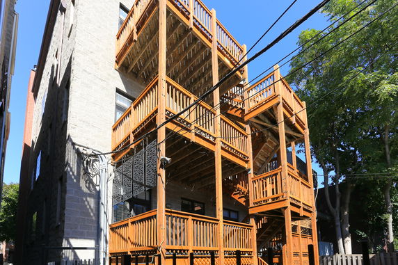 Rear view of a multi-story building with wooden balconies.