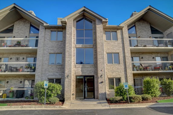 Front view of a multi-story apartment building with balconies.