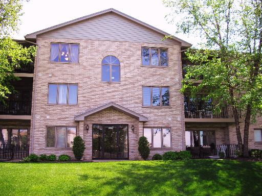 Front view of a multi-story building with a sloped roof and multiple windows.