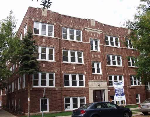 Front view of a multi-story brick apartment building.