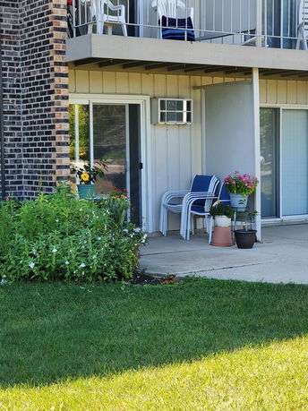 Front view of a two-story building with a small patio and balcony.