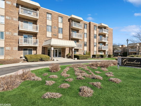 Front view of a condominium building with multiple balconies and entrance.