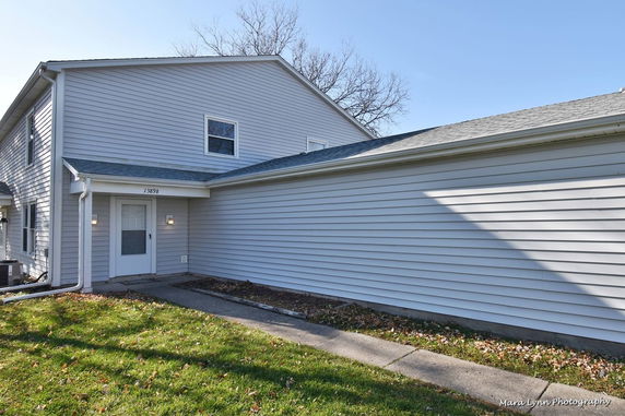 Front view of a two-story house with gray siding and an entrance door.