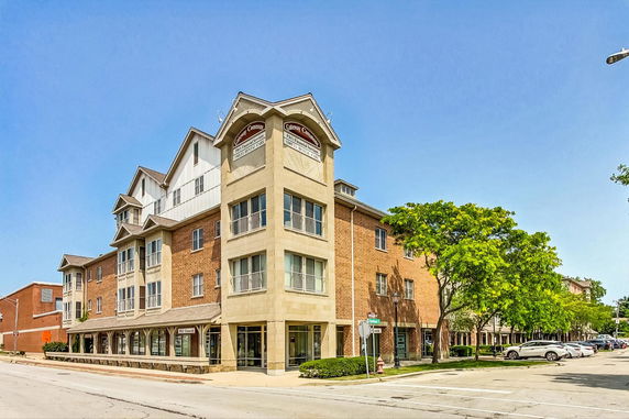 Front view of a multi-story brick building with large windows and prominent corner architecture.