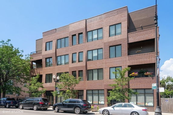 Front view of a modern four-story brick apartment building.