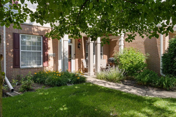 Front view of a brick house entrance with a covered porch.