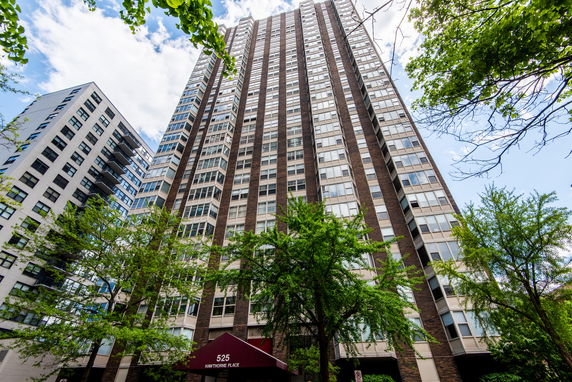 Front view of a high-rise residential building with multiple windows and brick facade.