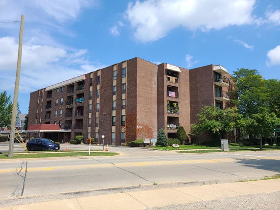 Front view of a multi-story brick apartment building.