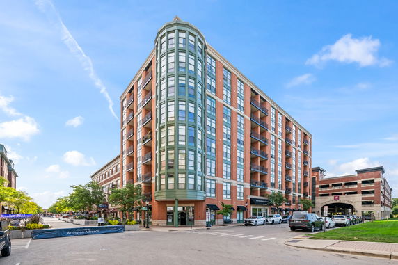 Front view of a multi-story apartment building with a rounded corner section.