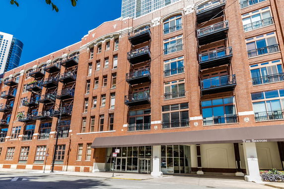 Front view of a multi-story brick building with balconies.